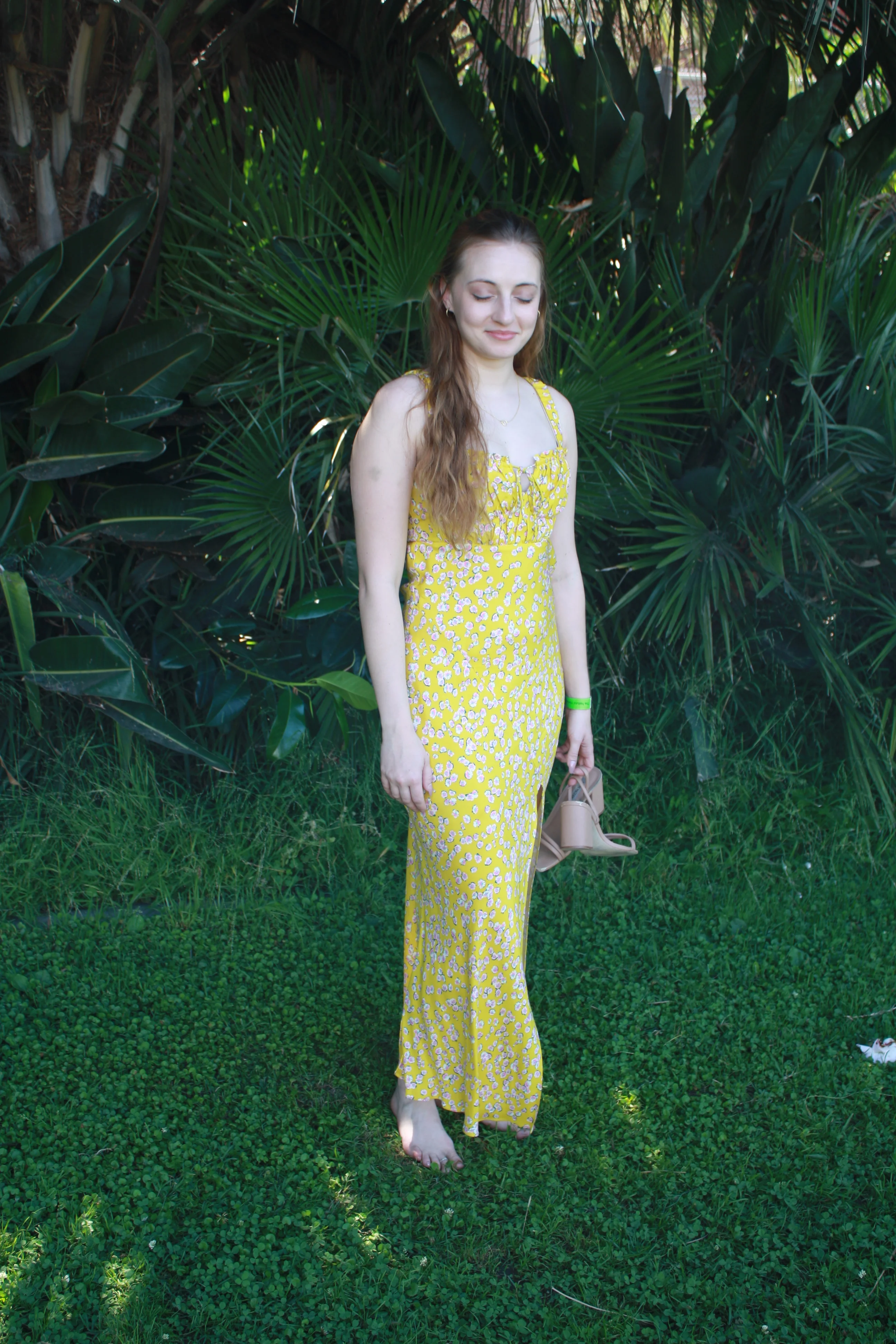 Jordie Morris looking down while standing beneath palm fronds at the Exposition Park Rose Garden.